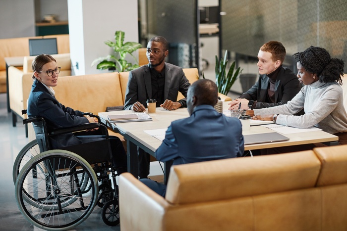A diverse business team meets around a table.
