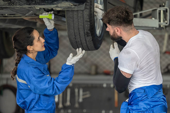 Technicians work to fix a vehicle