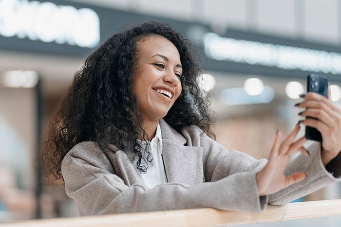Woman Using a Smartphone and Smiling
