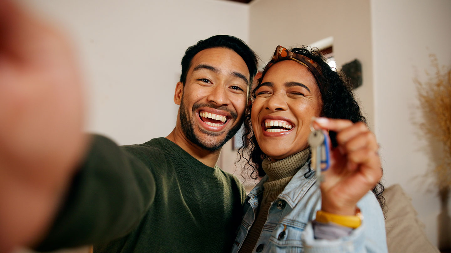 Happy couple smiles with new house keys