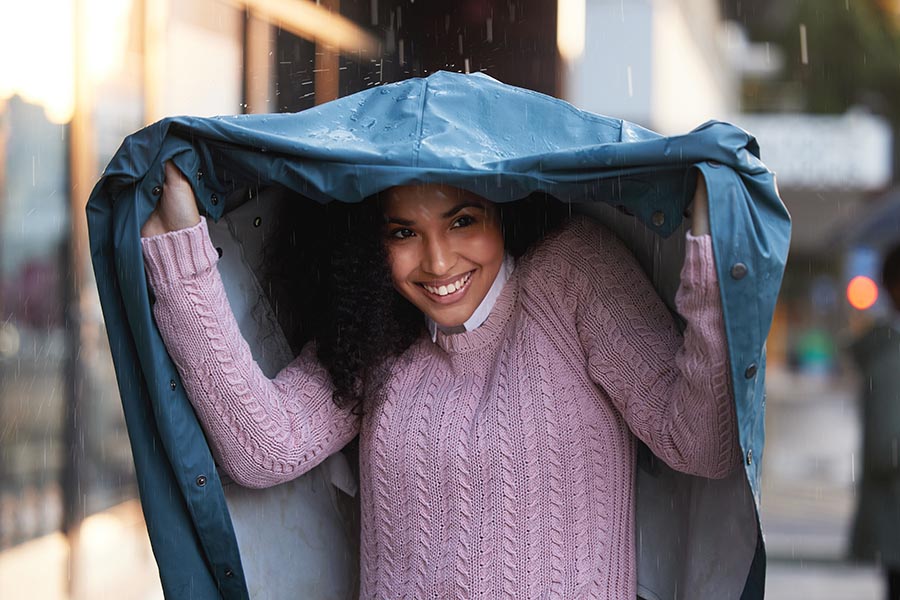 Woman using a jacket to protect herself from the rain