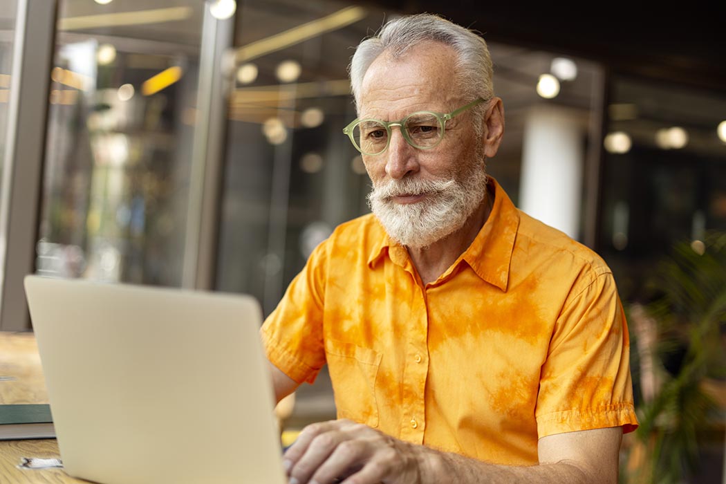Person with a beard using a laptop