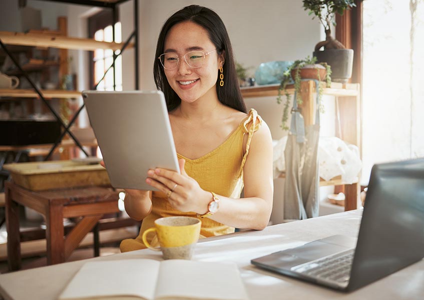 Woman smiling while reading from a tablet